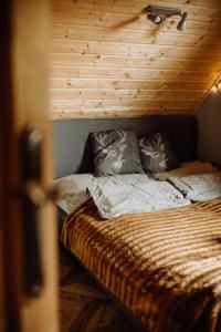 uma cama com duas almofadas num quarto em Szumilove Domki z saunami w Bieszczadach em Baligród