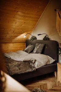 a bedroom with a bed with two lamps on it at Szumilove Domki z saunami w Bieszczadach in Baligród