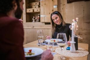 uma mulher sentada à mesa a comer comida em Hotel Alp Cron Moarhof em Valdaora