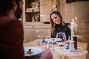 a woman sitting at a table eating food at Hotel Alp Cron Moarhof in Valdaora