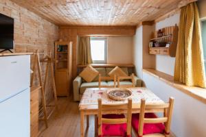 uma pequena cozinha com mesa e cadeiras num quarto em casa Balto em Passo del Tonale