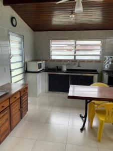 a kitchen with a table and a microwave at Suite 237 in Itanhaém