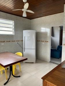 a kitchen with a white refrigerator and a table at Suite 237 in Itanhaém