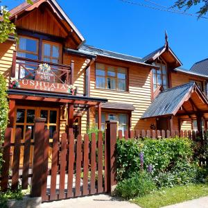 una casa de madera con una valla delante en Ushuaia Lodge Las Margaritas 430 en Ushuaia