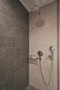 La salle de bains est pourvue d'une douche avec un pommeau de douche. dans l'établissement Hestia - Dimitressa 4, à Athènes
