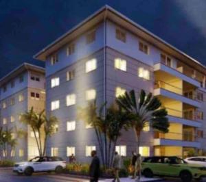 un gran edificio con coches estacionados frente a él en 3 bdrm Cityview Apt with Pool, Gym & Children Playground, en Accra