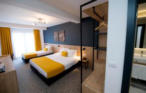 um quarto de hotel com duas camas e uma casa de banho em City Inn em Pristina