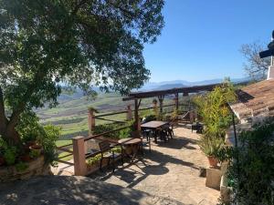 un patio con mesas y sillas y vistas. en Finca Sábila, en Valle de Abdalajís