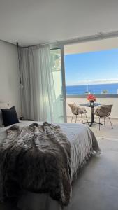 een slaapkamer met een bed en uitzicht op de oceaan bij Boutique studio, sea views of Las Vistas and free wifi in Playa de las Americas