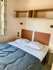 uma cama num pequeno quarto com em Camping les Chênes em Chauzon