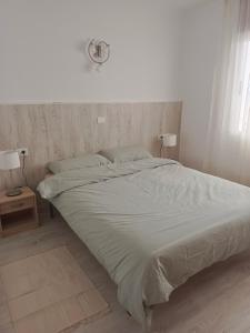 a large bed in a white room with two lamps at Sunset view in La Romantica, 3 in Los Realejos