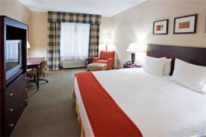 ein Hotelzimmer mit einem Bett und einem Flachbild-TV in der Unterkunft Holiday Inn Express Hotel & Suites Freeport, an IHG Hotel in Freeport