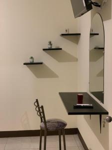 a table and a chair in a room with shelves at Hermoso departamento cerca de todo in Guayaquil