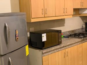 a microwave sitting on a kitchen counter next to a refrigerator at Hermoso departamento cerca de todo in Guayaquil