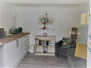 a living room with a couch and a book shelf at Willow Valley Glamping in Bude