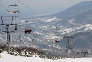 a group of people riding on a ski lift in the snow at Apartamenty Beskidzkie in Ustroń