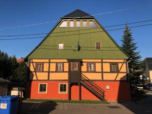 ein großes Haus mit grünem Dach in der Unterkunft Ferienwohnung im Erzgebirge in Großhartmannsdorf
