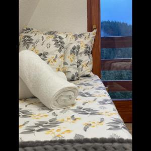 a bed with a pillow and a towel on it at The Tara Concept in Šljivovica