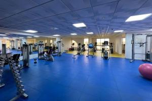 a gym with treadmills and machines in a room at Cozy 1 Bed in Sports City in Dubai