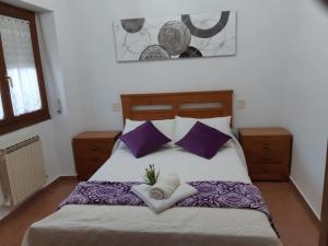 1 dormitorio con 1 cama grande con almohadas moradas en Casa Rural-Casa Murgui, 