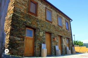 un edificio de ladrillo con puertas y ventanas de madera en Casa da Comareira, en Góis