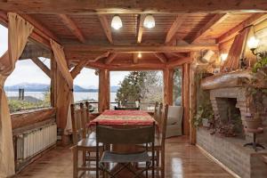 comedor con mesa y chimenea en Casa con vista al lago - La casa de Berta en San Carlos de Bariloche