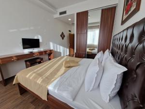 波德戈里察的住宿－Motel Celebic，一间卧室配有一张带皮革床头板的大床