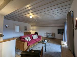 a living room with a red couch and a table at Ferienwohnung Murnauer Moos in Murnau am Staffelsee