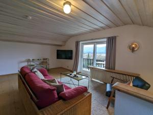 a living room with a couch and a large window at Ferienwohnung Murnauer Moos in Murnau am Staffelsee