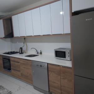 cocina con armarios blancos y microondas en شقة بمنتجع مياتيرمال, en Kaplıca