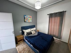 een slaapkamer met een blauw bed en een raam bij Bidani Villa in Essaouira +34 foto's