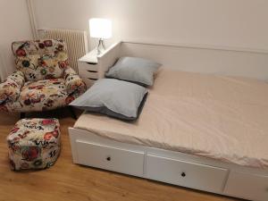 a bed and a chair in a bedroom at 1min BusStop to St Germain En Laye - Chambourcy Center - Wei&Pei Apartment in Chambourcy