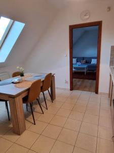 comedor con mesa, sillas y sofá en Bohém Apartman, en Nyergesújfalu