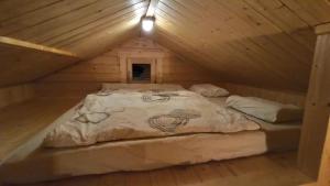 Bett in einer Holzhütte mit Dach in der Unterkunft Happy Cottage 