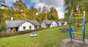 um parque infantil em frente a uma fila de casas em Roman Tarnawa "Nasz Domek" em Szczytna