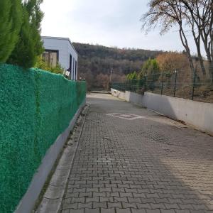 a cobblestone street with a green fence on the side at شقة بمنتجع مياتيرمال in Kaplıca