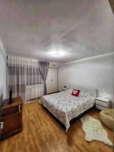 um quarto com uma cama com uma almofada vermelha em La Simo em Sinaia