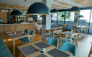 a restaurant with tables and chairs and a bar at City Inn in Pristina