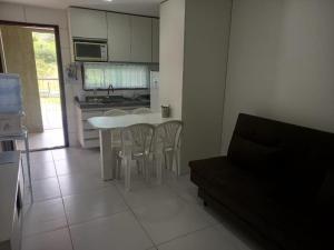 a kitchen with a white table and chairs in a room at FLAT VILLA MONTE CASTELO in Bezerros
