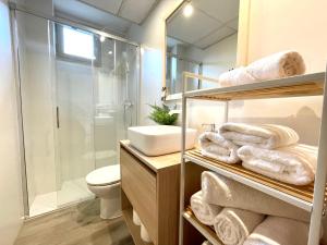 a bathroom with a shower toilet and towels at Apartamentos LÓRIEN Candanchú in Candanchú