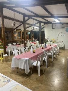 een groep tafels en stoelen met roze tafelkleden bij Feliz Amanecer in Sáchica