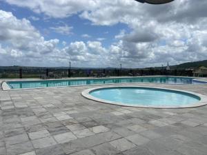 an empty swimming pool with a cloudy sky at FLAT VILLA MONTE CASTELO in Bezerros