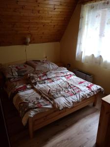 - un lit avec une couette dans une chambre dans l'établissement M&M Chata Kokava Línia, à Å oltÃ½ska