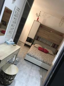 um quarto com uma cama com almofadas vermelhas e uma mesa em Appartement confortable centre du village em Pélussin