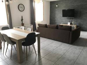 uma sala de estar com uma mesa e um sofá em Appartement confortable centre du village em Pélussin