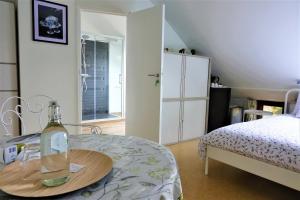 Le Jardin des Miroirs في Esneux: غرفة نوم مع سرير وزجاجة على طاولة