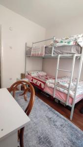 Cette chambre comprend 2 lits superposés et une table. dans l'établissement Private room for friends, à Konak