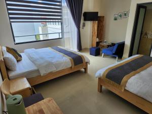 um quarto de hotel com duas camas e uma janela em K Bình Phương Hotel em Da Lat
