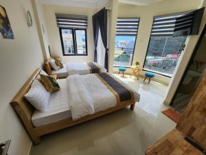 a bedroom with two beds and a large window at K Bình Phương Hotel in Da Lat