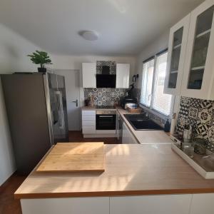 a kitchen with a wooden cutting board on a counter at Villa standing 10 personnes piscine/ pinède in Canet-en-Roussillon